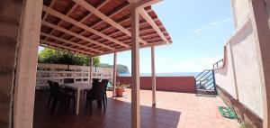 a patio with a table and chairs and the ocean at Beach House Buljarica in Petrovac na Moru