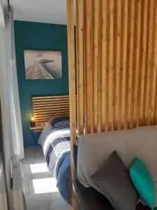 a bedroom with a bed with a wooden head board at Beau studio avec balcon in Bagnères-de-Bigorre