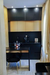 uma cozinha preta com uma mesa preta e cadeiras em Apartmani President I em Banja Luka