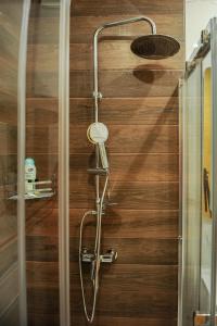 a shower with a shower head on a wooden wall at Apartmani President I in Banja Luka