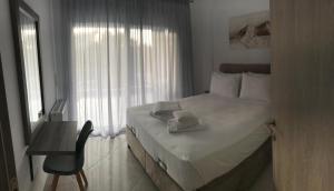 una camera d'albergo con un letto e un asciugamano sopra di Cyclops Luxury Apartments a Igoumenítsa