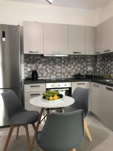 una cocina con una mesa con un bol de fruta. en Cyclops Luxury Apartments en Igoumenitsa