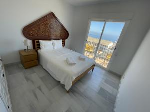 1 dormitorio con cama y ventana grande en Casa Carino, en La Herradura