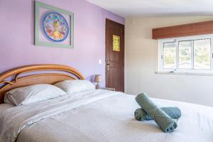 a bedroom with a bed with a teddy bear on it at Natural Mystic Hostel in Costa da Caparica