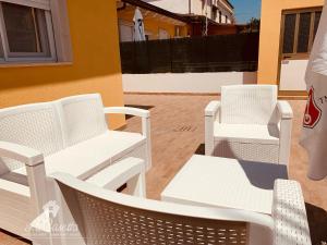 - un ensemble de chaises et de tables blanches sur une terrasse dans l'établissement La Casetta, à SantʼEufemia Lamezia