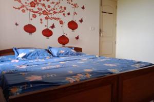 a bed with a blue comforter with birds on it at Sea Breeze Homestay with pool in Trivandrum +45 photos