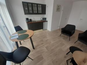 a room with a table and chairs and a kitchen at Huize de Koeie in Westkapelle