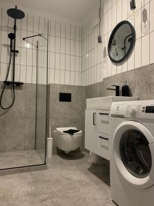 een badkamer met wasmachine en toilet bij Apartament 44 in Szczecin