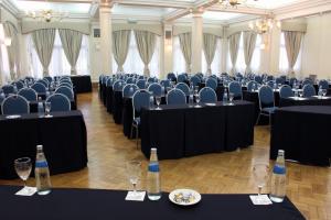 a room with black tables and chairs and bottles at Hotel Colonial San Nicolás in San Nicolás de los Arroyos