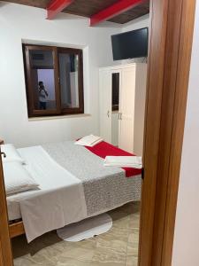 a small bedroom with a bed and a mirror at Colle Sul Lago in Cingoli
