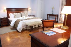 a bedroom with a bed and a desk and a table sidx sidx sidx at Hotel Colonial San Nicolás in San Nicolás de los Arroyos