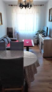 uma sala de estar com uma mesa e um sofá em Apartment Modric em Senj