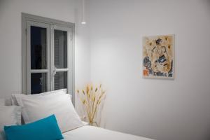 a bedroom with a bed and a painting on the wall at Cape Suite Oia in Oia
