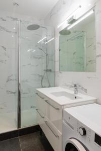 een badkamer met een glazen douche en een wastafel bij DIFY Castries Quartier Ainay in Lyon