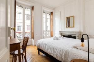 een witte slaapkamer met een bed en een open haard bij DIFY Castries Quartier Ainay in Lyon