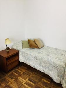 Cama en habitación con mesita de noche y cama sidx sidx en Penthouse Malva Rosa, en Montevideo