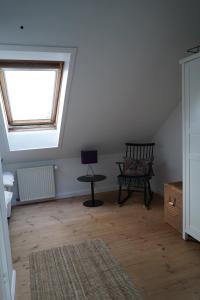 an attic room with a chair and a window at Homely 2 room Apartment close to Copenhagen city center in Copenhagen