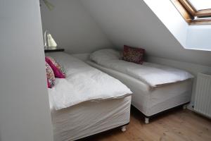 Habitación pequeña con 2 camas y ventana en Homely 2 room Apartment close to Copenhagen city center en Copenhague