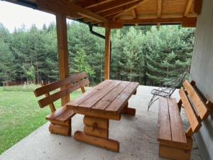 a wooden picnic table and two benches on a porch at Sarajevo Nisici Vila Nature in Sarajevo