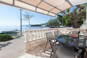 un patio con mesa, sillas y agua en Apartments Orka, en Promajna