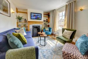a living room with a blue couch and chairs and a fireplace at Church Bells House by Spa Town Property - 3 Bedroom Georgian Townhouse in Central Warwick in Warwick