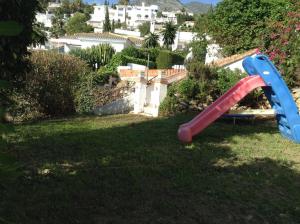 een rode en blauwe glijbaan in een tuin bij 2 bedrooms villa with sea view private pool and furnished terrace at Benalmadena 2 km away from the beach in Benalmádena