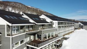 a building with solar panels on it in the snow at Ustedalen Resort Leiligheter in Geilo