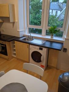 a kitchen with a sink and a washing machine at Glenclova - No 5 Bellyeoman, bright two bedroom apartment in Fife +20 photos
