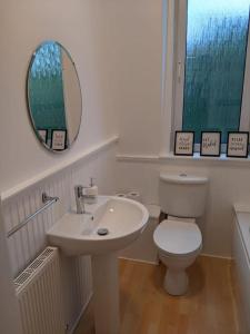 een badkamer met een toilet, een wastafel en een spiegel bij 'No.5' Bellyeoman in Fife