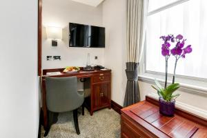 a hotel room with a desk and a window at Gem Fitzrovia Hotel in London