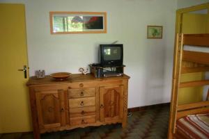 ein Zimmer mit einem Fernseher auf einer Kommode mit einem Bett in der Unterkunft appartement 6 personnes au coeur de super besse in Besse-et-Saint-Anastaise