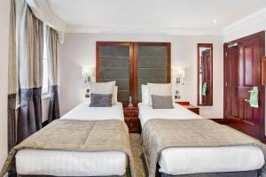 a hotel room with two beds and a window at Gem Fitzrovia Hotel in London