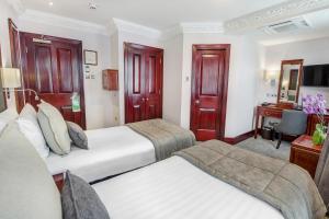 a hotel room with two beds and a desk at Gem Fitzrovia Hotel in London