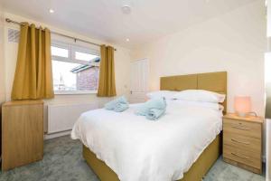 a bedroom with a large white bed and a window at Apple Tree Bungalow in Thornton