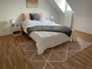 1 dormitorio con 1 cama grande con sábanas blancas y almohadas rosas en UrbanSuites - Stylish Apartments I Koblenz Center I Kitchen I up to 115m2 en Koblenz