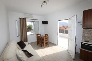a living room with a white couch and a table at Angelos Apartments in Lixouri +12 photos