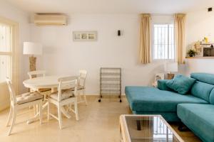 a living room with a blue couch and a table at Apartamento Confortable Urbanización El Paraiso in Estepona