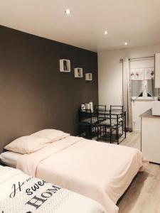 a bedroom with two beds and a black wall at Cozy in Bussy-Saint-Georges