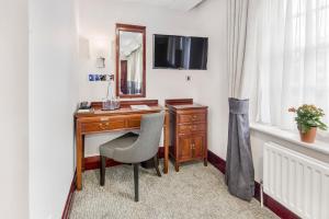 a desk with a mirror and a chair in a room at Gem Fitzrovia Hotel in London