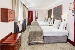 a row of beds in a hotel room at Gem Fitzrovia Hotel in London
