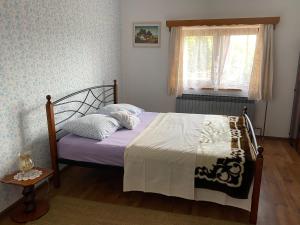 - une chambre avec un lit doté de draps violets et une fenêtre dans l'établissement Villa Mirela, à Maretić