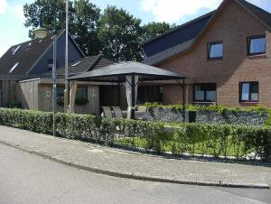 a house with an umbrella and chairs in front of it at Ferienwohung Hanl - schöne FeWo mit 2 Schlafzimmern mit TV, Garten und großem Badezimmer in Wanderup