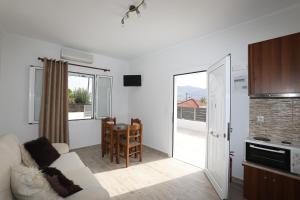 a living room with a white couch and a kitchen at Angelos Apartments in Lixouri
