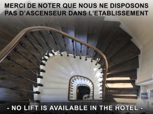 Un escalier en colimaçon se trouve dans un bâtiment sans ascenseur. dans l'établissement Le Grand Hôtel Mont Dore, à Le Mont-Dore