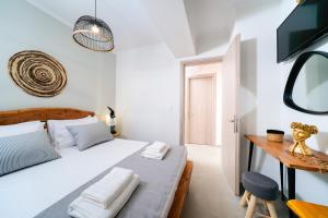 a white bedroom with a bed and a chair at Videre Luxury Suites in Potos +21 photos