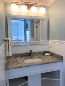 a bathroom with a sink and a large mirror at Falmouth Heights Motor Lodge in Falmouth