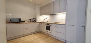 eine weiße Küche mit weißen Schränken und Holzböden in der Unterkunft Apartement Insel Usedom Swinemünde in Świnoujście