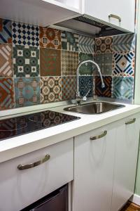 una cucina con mobili bianchi e un lavandino di Inner Naples a Napoli Altre 19 foto