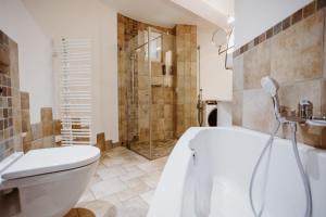 een badkamer met een bad, een toilet en een douche bij Ferienwohnung Wasserturm Thale in Thale +10 foto's