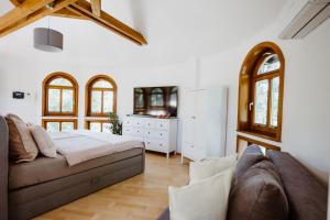 um quarto com uma cama, um sofá e janelas em Ferienwohnung Wasserturm Thale em Thale